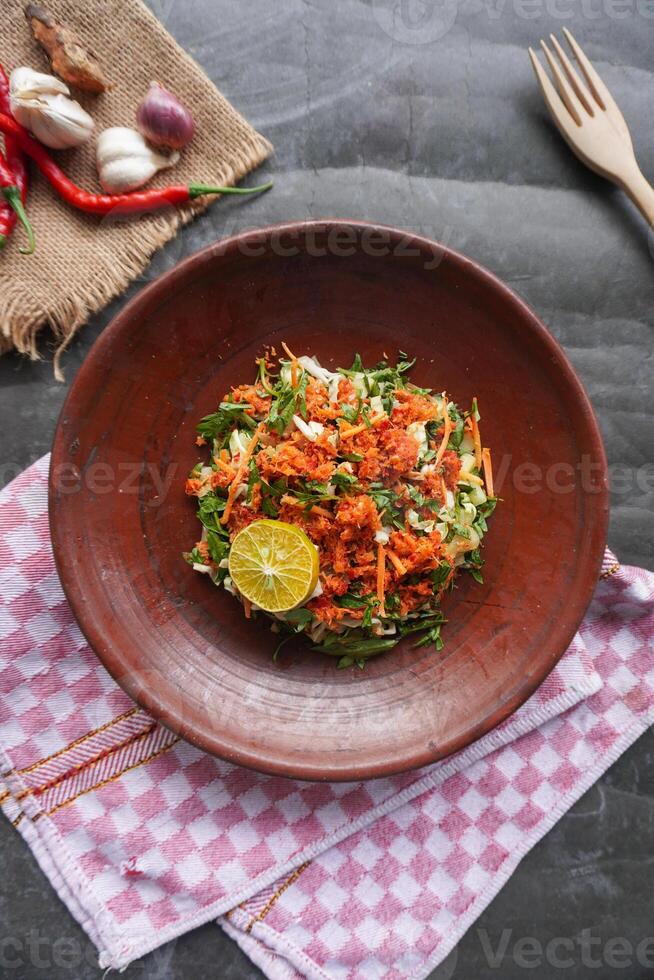Trancam is a traditional salad from Java, Indonesia made from fresh vegetables such as cucumber, basil, long beans, and white cabbage, which are cut into pieces and photo