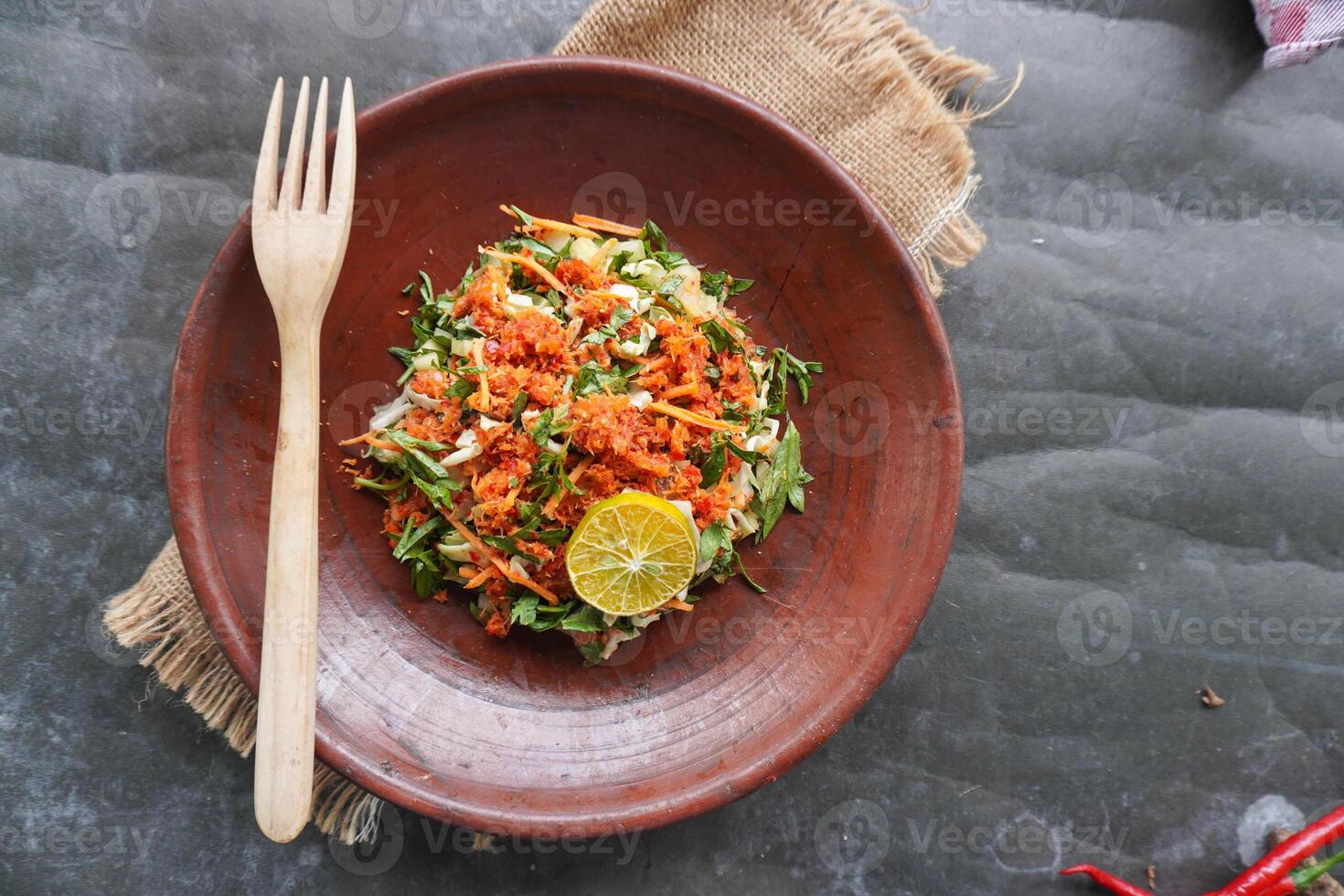Trancam is a traditional salad from Java, Indonesia made from fresh vegetables such as cucumber, basil, long beans which are cut into pieces and mixed with grated coconut with spices. photo