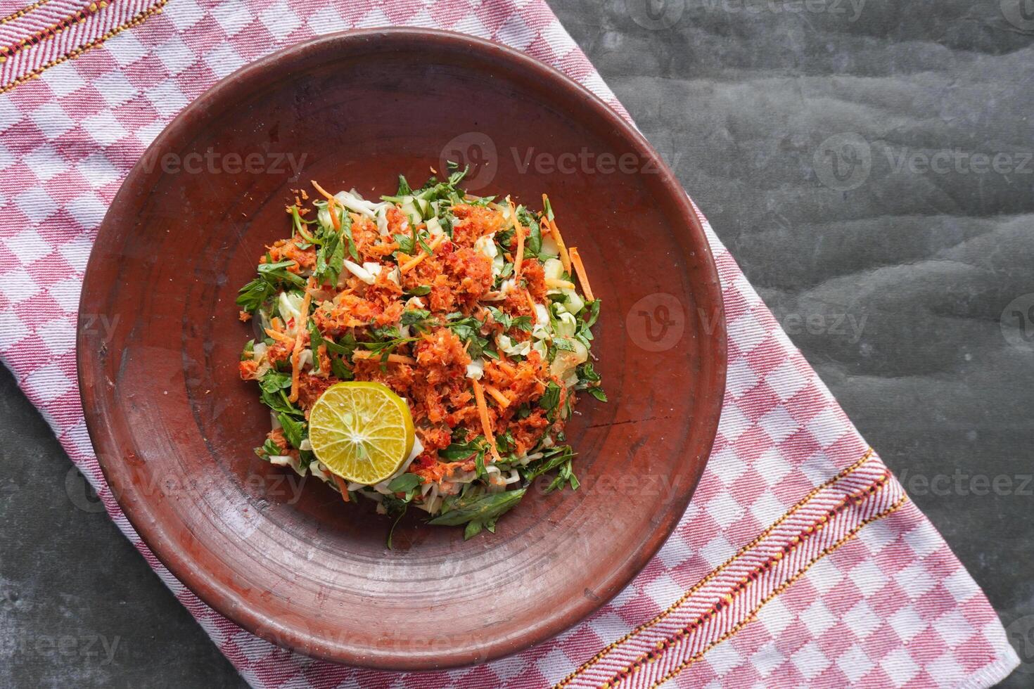Trancam is a traditional salad from Java, Indonesia made from fresh vegetables such as cucumber, basil, and white cabbage, which are cut into pieces and mixed with grated coconut with spices. photo