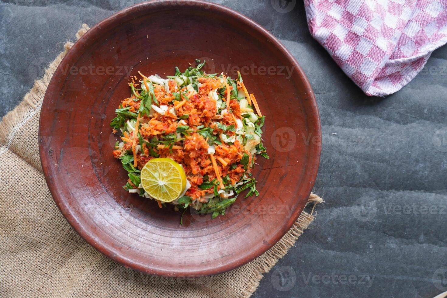 Trancam is a traditional salad from Java, Indonesia made from fresh vegetables such as cucumber, basil, long beans, and white cabbage, which are cut into pieces and mixed with grated coconut photo