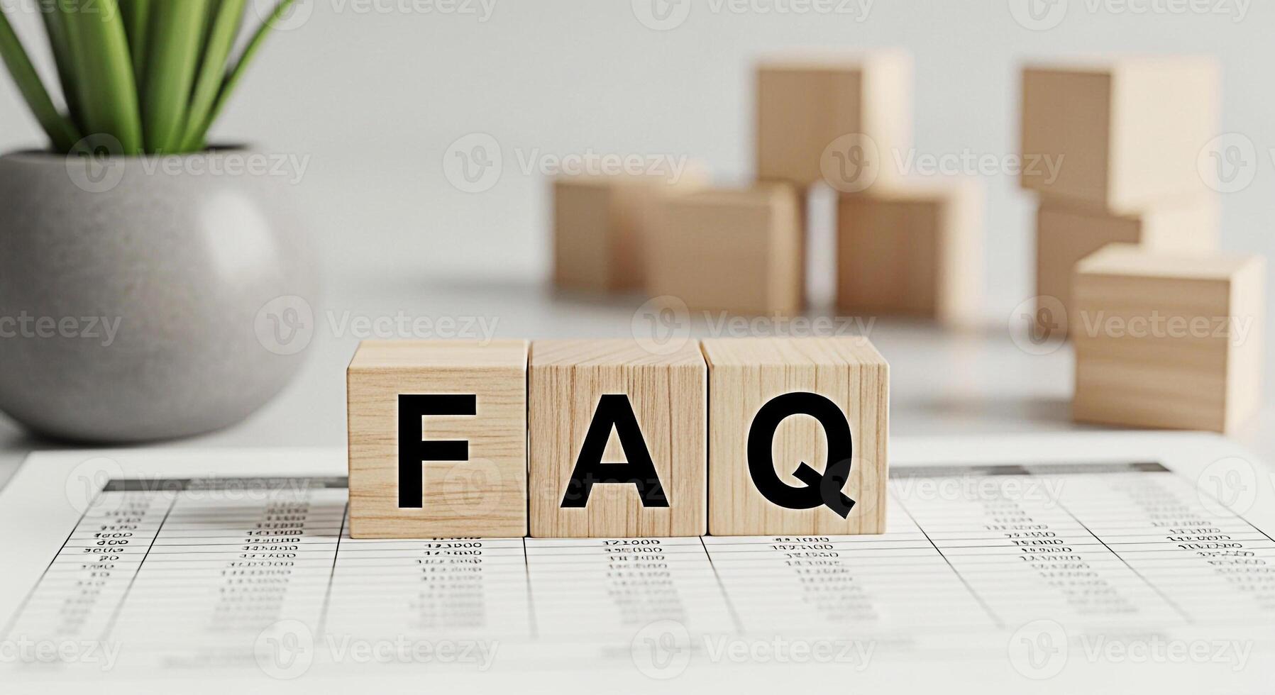 Wooden blocks spelling FAQ on a financial report in a bright office setting representing frequently asked questions and providing answers with clarity and helpful information for customer support photo