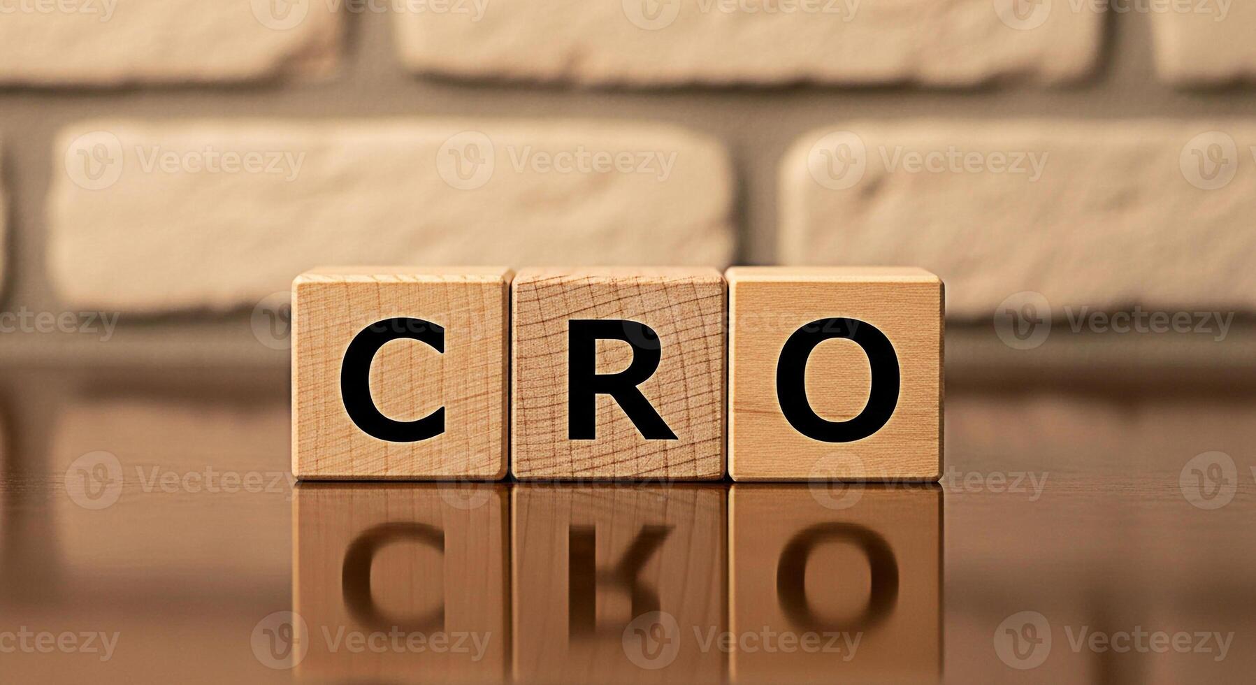 Wooden blocks displaying CRO on a reflective surface against a brick wall symbolizing Conversion Rate Optimization and its importance in digital marketing and business growth strategies photo
