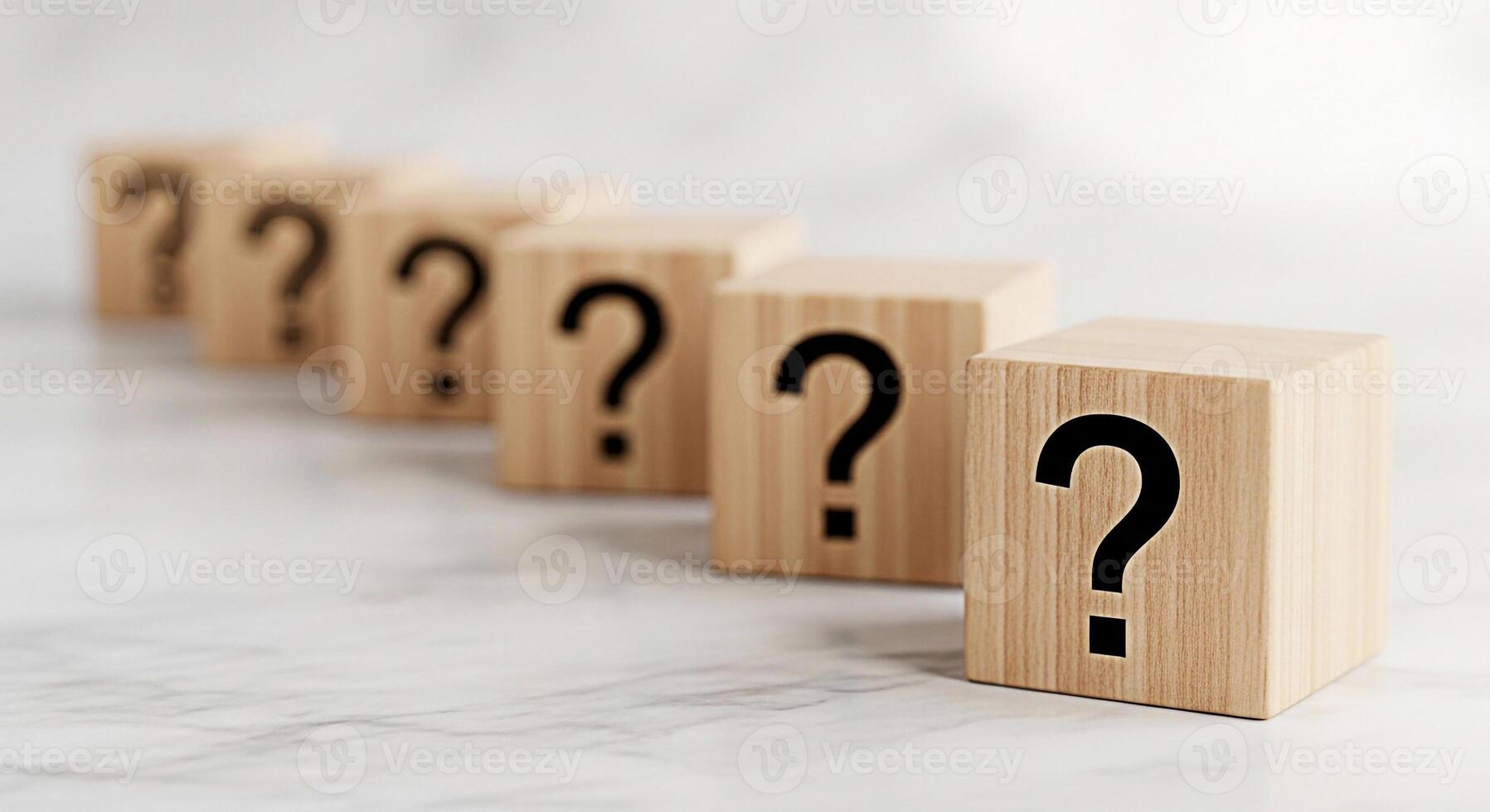 A row of wooden blocks displaying question marks on a marble surface representing uncertainty and the need for answers creating a sense of mystery and intellectual curiosity in a bright clean setting photo