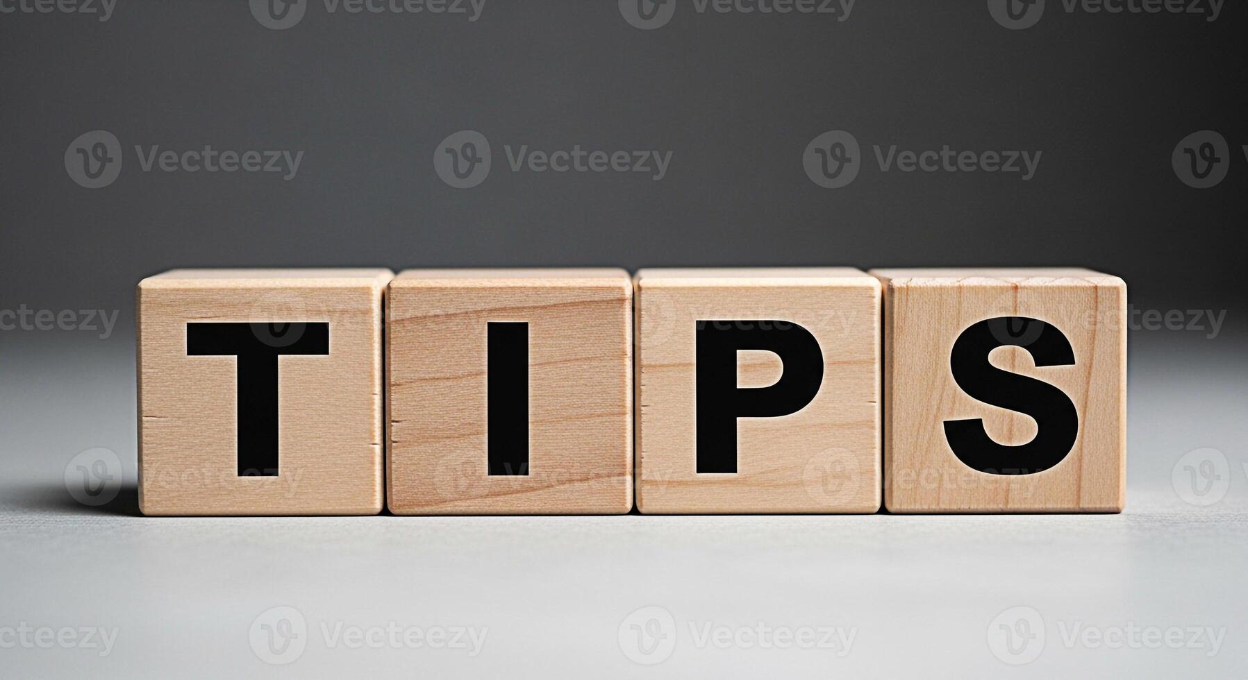 Wooden blocks spelling TIPS on a neutral surface offering guidance and advice in a simple clean presentation conveying helpful information and expert knowledge for problemsolving and decisionmaking photo