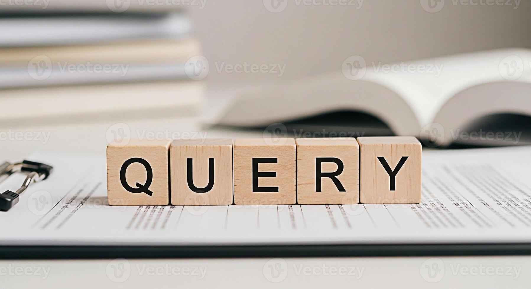 Wooden blocks spelling QUERY resting on a document on a clipboard in a bright office setting symbolizing research investigation and the pursuit of knowledge with a focus on information retrieval photo