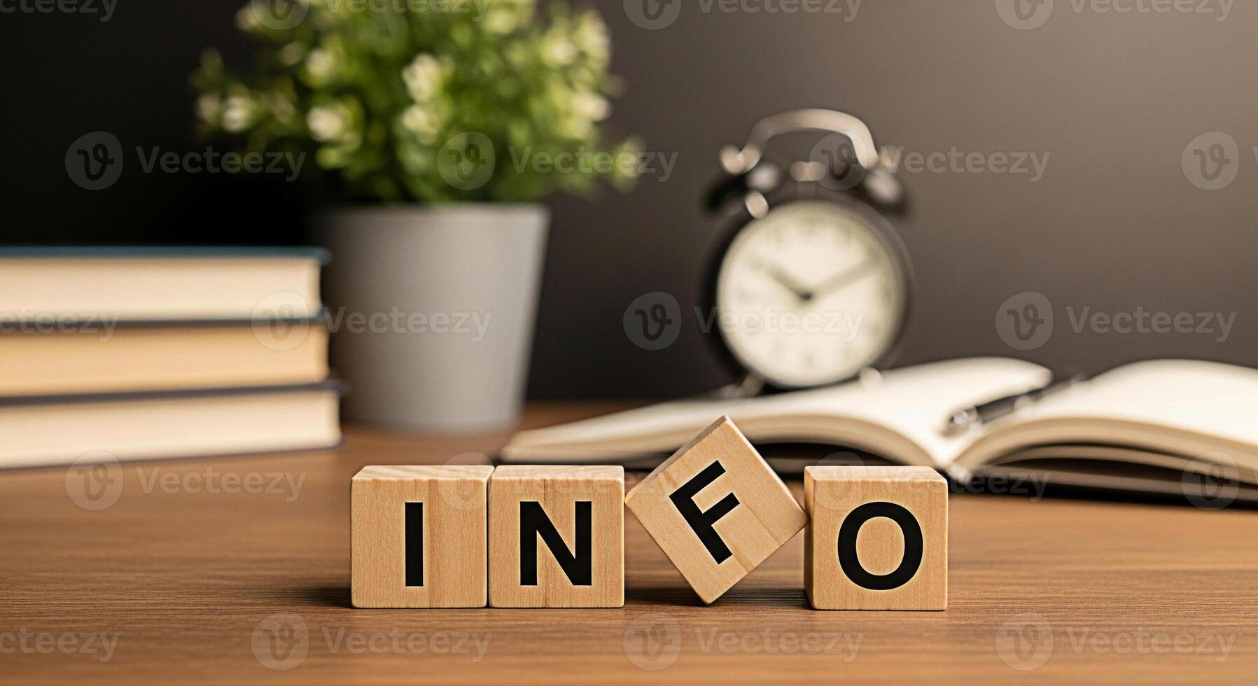 Wooden blocks spelling INFO on a desk with books a plant and a clock symbolizing knowledge learning and the importance of information in education and time management in a study environment photo