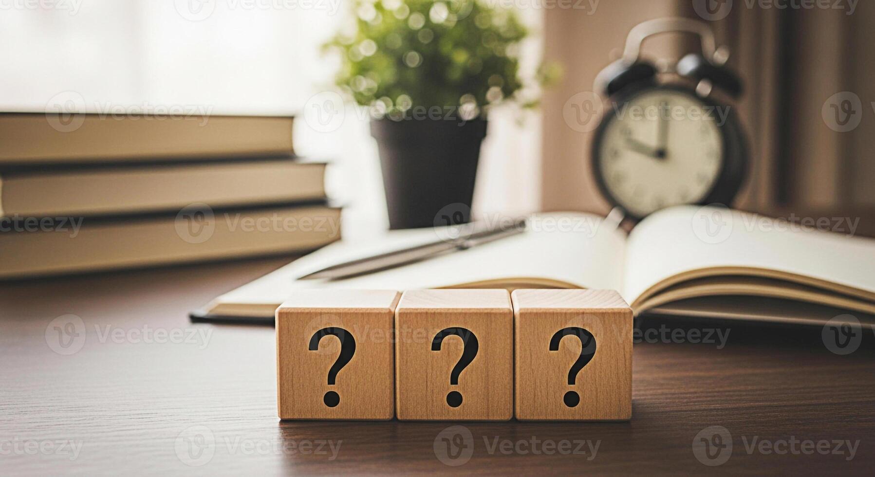 Three wooden blocks displaying question marks sit on a desk with books and an open notebook symbolizing uncertainty and the search for answers in a learning environment creating a mood of inquiry photo