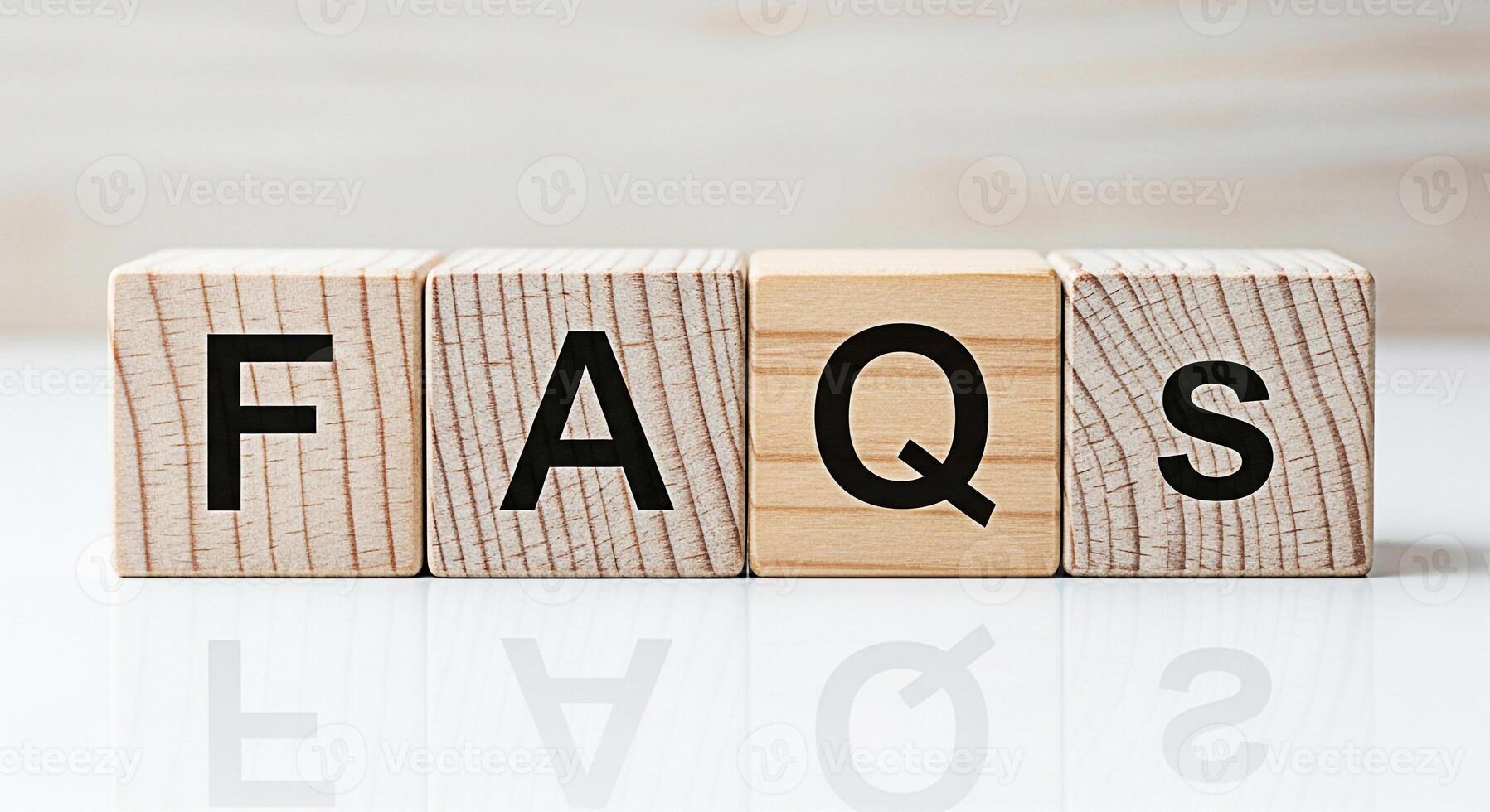 Wooden blocks displaying FAQs on a white surface representing frequently asked questions and providing helpful information in a clear and accessible manner promoting clarity and understanding photo