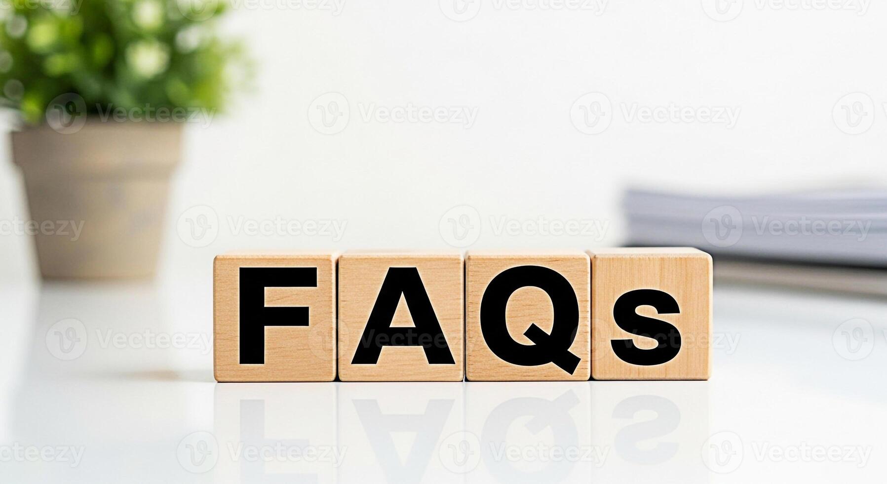 Wooden blocks spelling FAQs on a white table in a bright office setting representing information support and frequently asked questions for customer service and online assistance photo