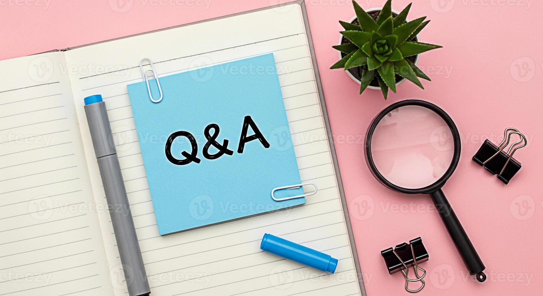 Questions and Answers concept on a blue sticky note in a notebook with a pen and magnifying glass on a pink desk representing knowledge learning and problemsolving in a bright and organized workspace photo