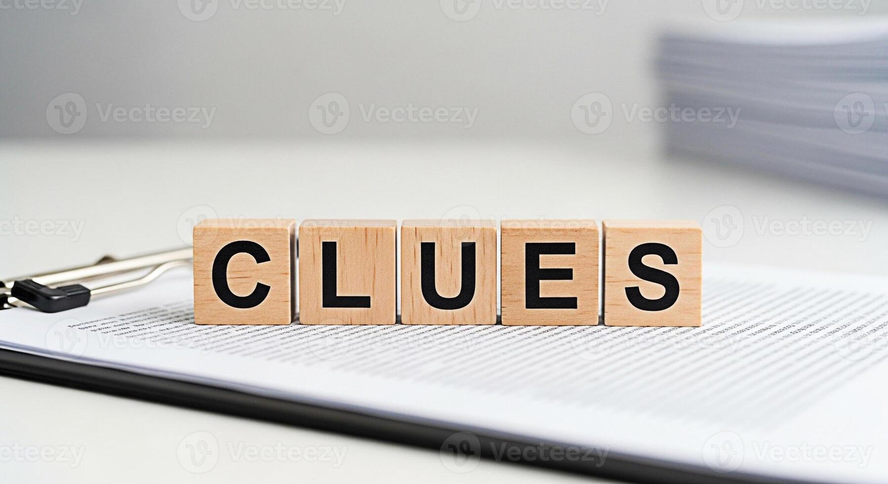 Wooden blocks spelling Clues resting on a clipboard with documents in a bright office setting symbolizing investigation problemsolving and the pursuit of answers with a clean and professional aestheti photo