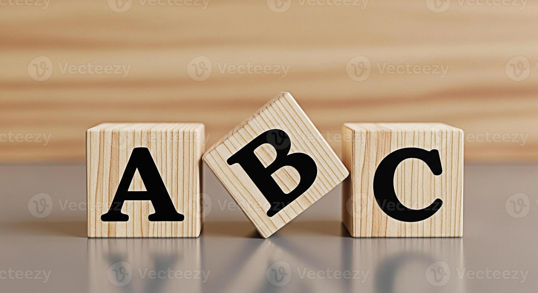 Wooden alphabet blocks displaying A B and C on a gray surface against a wooden background representing early childhood education and learning the basics with a playful and educational concept photo