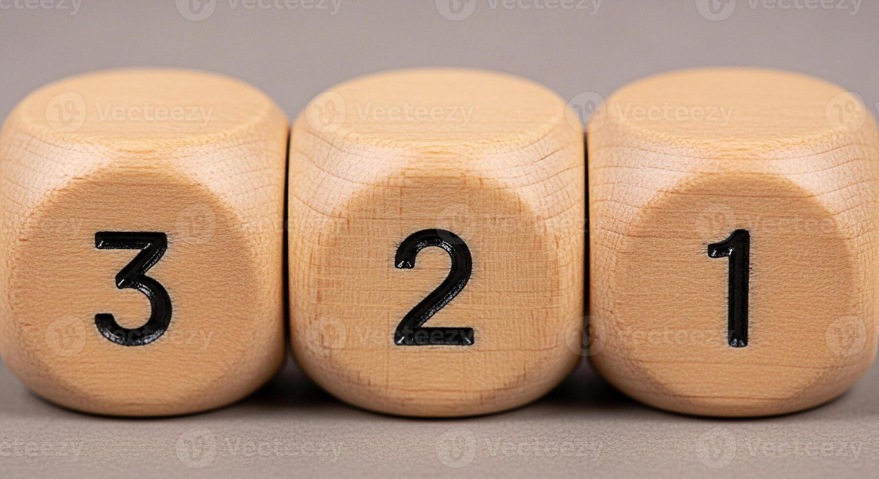 Closeup of three wooden dice showing the numbers 3 2 and 1 in a studio setting symbolizing countdown sequence and order creating a sense of anticipation and precision on a neutral background photo