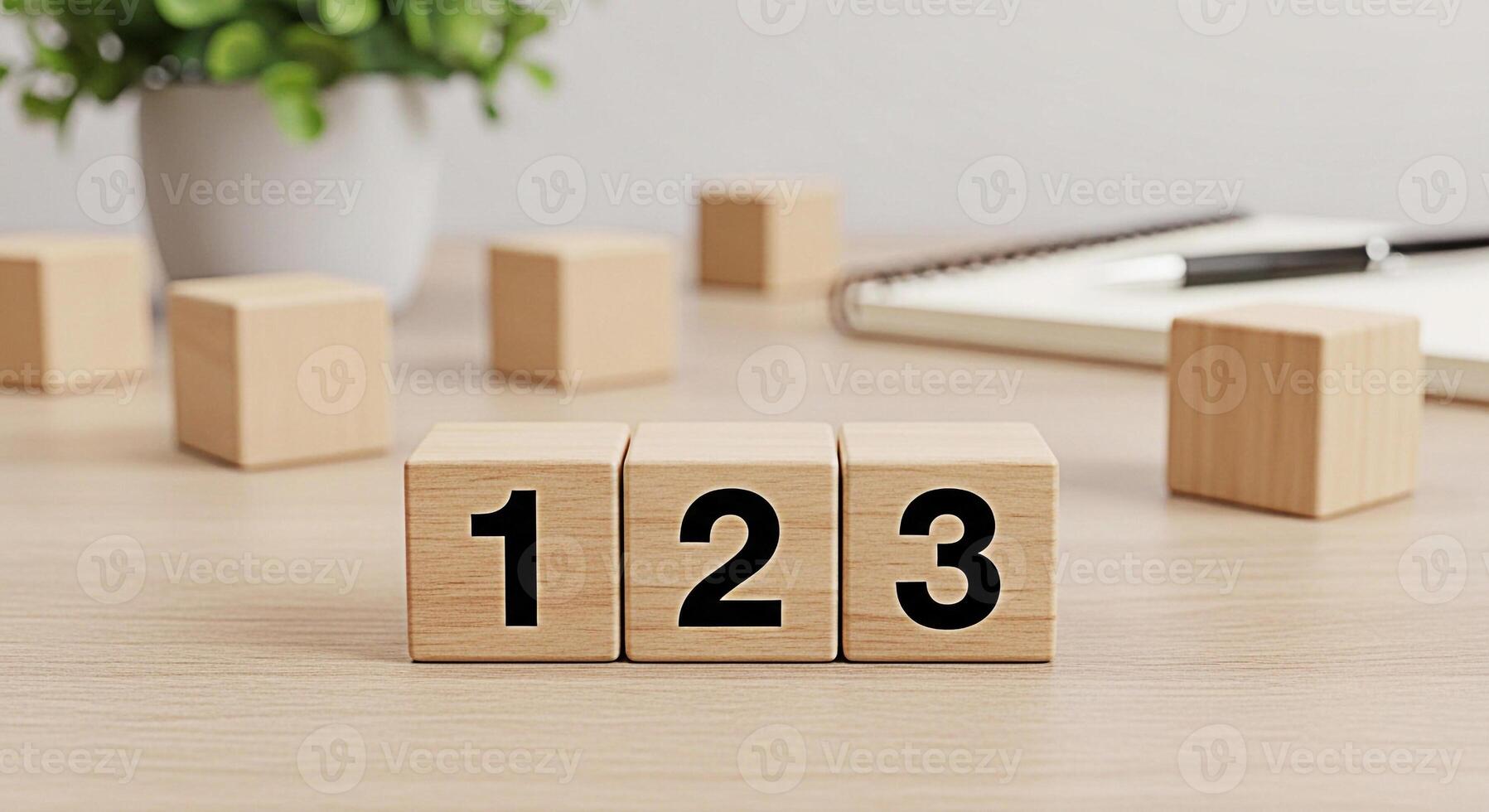 Wooden number blocks displaying 1 2 and 3 on a bright wooden desk surrounded by a plant and notebook representing early learning counting and basic math skills in a clean organized setting photo