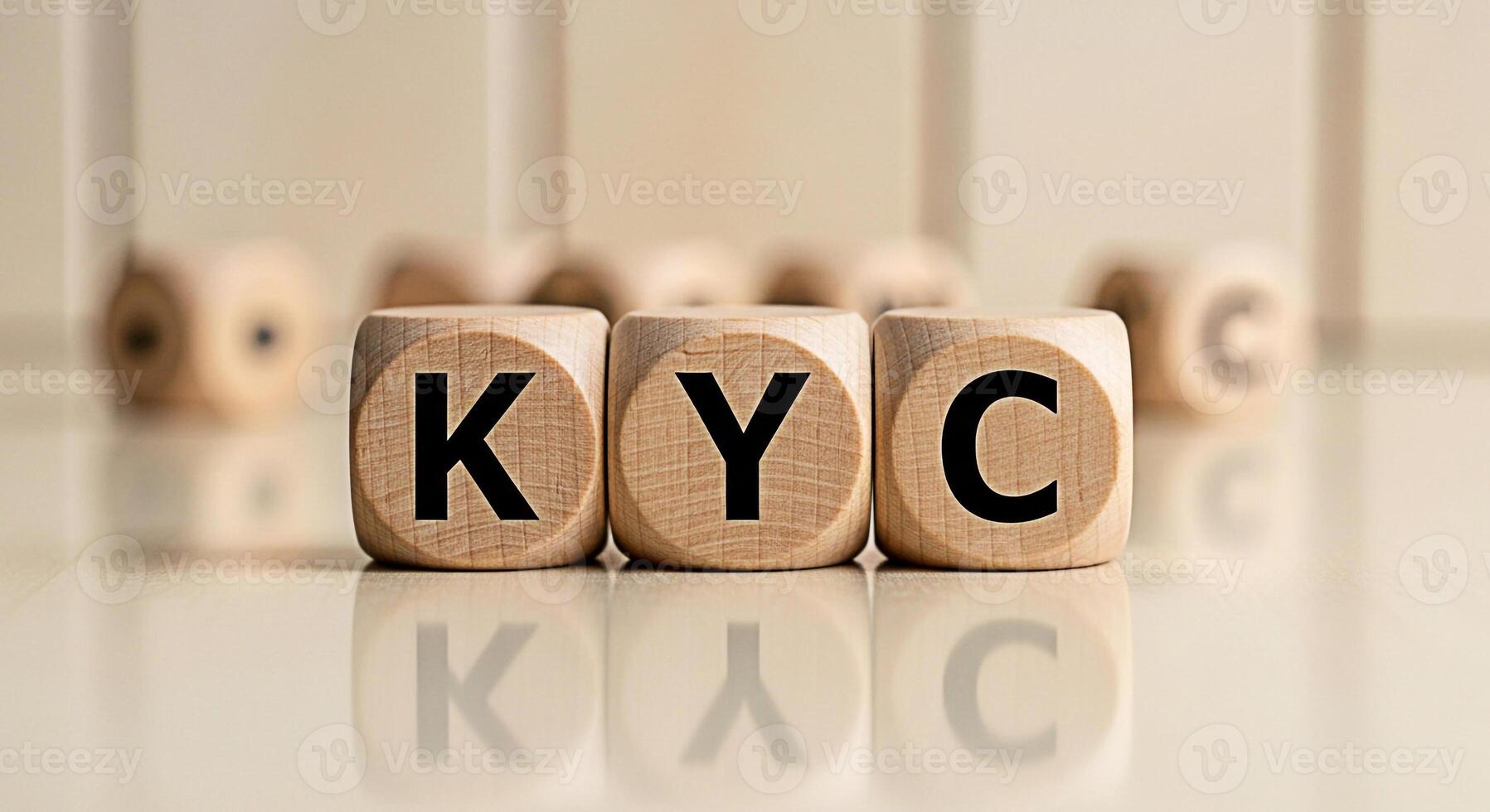 KYC letters displayed on wooden blocks arranged on a reflective surface representing the concept of regulatory compliance and identity verification in a financial or business setting photo