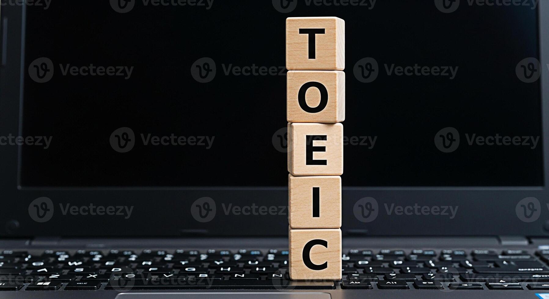 TOEIC wooden blocks stacked on a laptop keyboard in a learning environment representing test preparation and educational success symbolizing language proficiency and career advancement photo