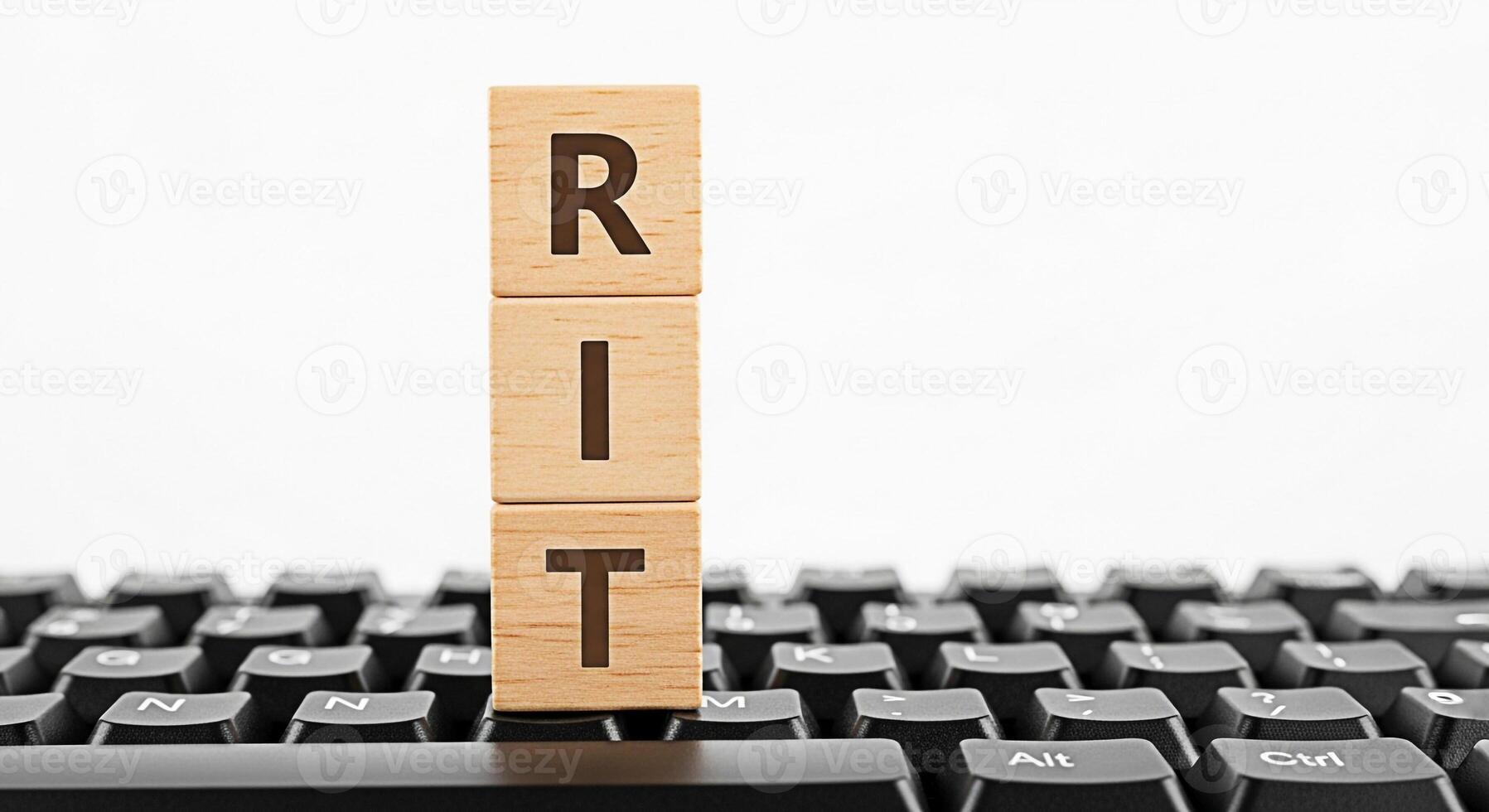 Wooden blocks spelling RIT resting on a black computer keyboard against a white background symbolizing technology education and the Rochester Institute of Technology with a clean and modern aesthetic photo