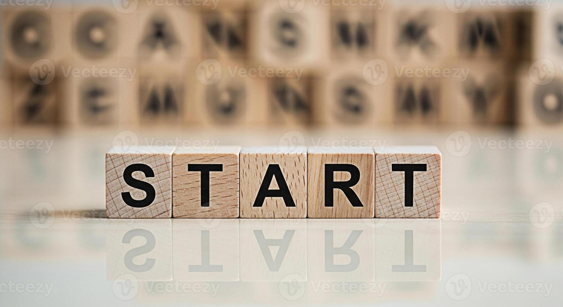 Wooden blocks spelling START on a reflective surface symbolizing a fresh beginning and motivation in a bright optimistic setting with blurred background blocks conveying a sense of focus and achieveme photo