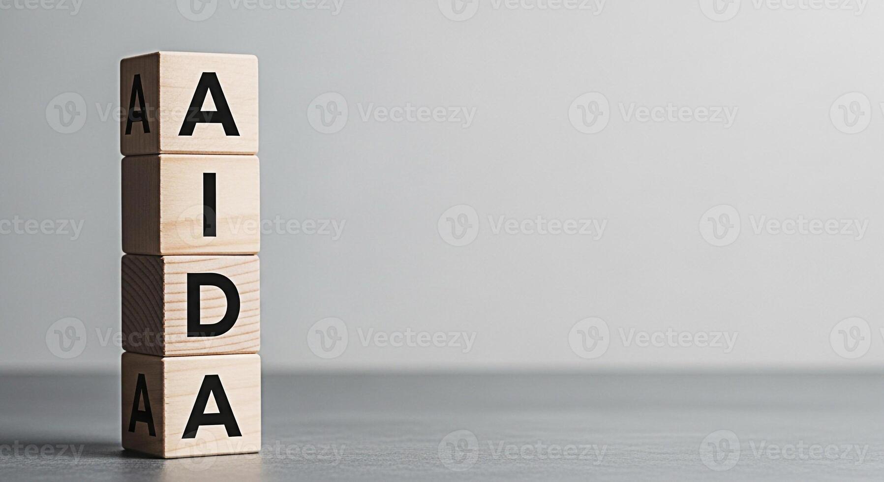 Wooden blocks stacked vertically displaying the acronym AIDA in a minimalist studio setting representing the marketing funnel stages of awareness interest desire and action conveying a message of stra photo