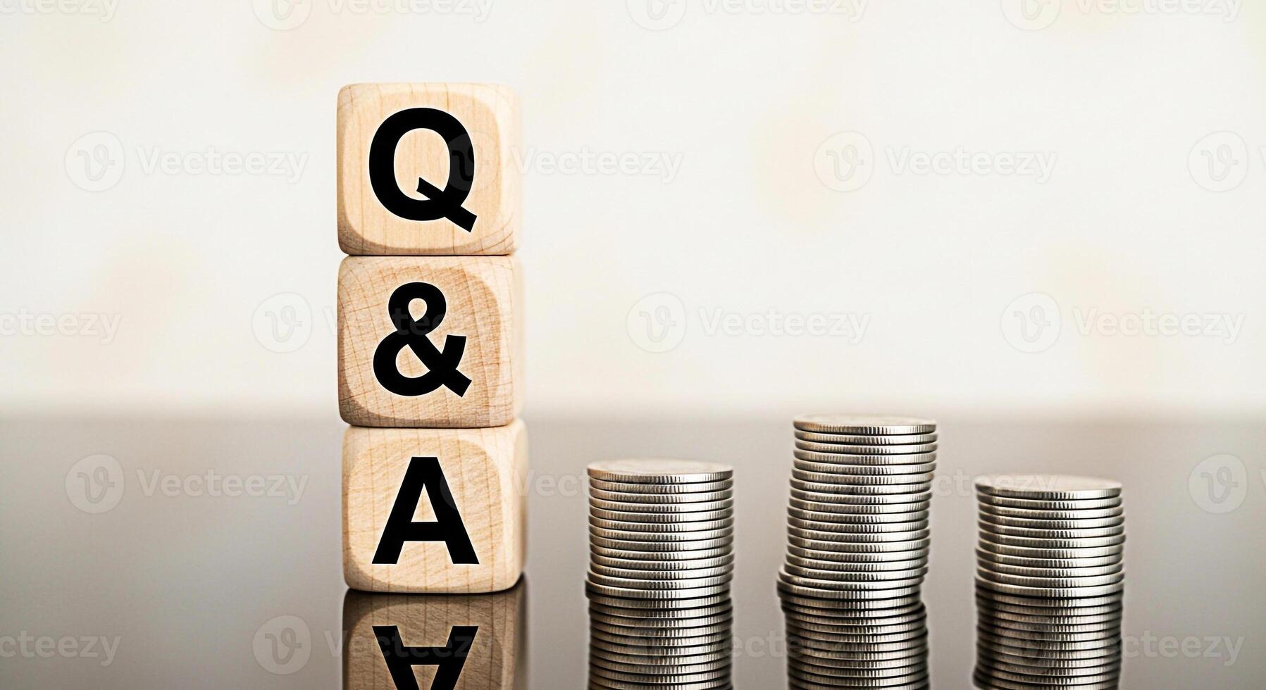 Wooden blocks displaying Q A sit beside stacks of coins on a reflective surface representing financial questions and answers economic insights and investment knowledge in a business setting photo