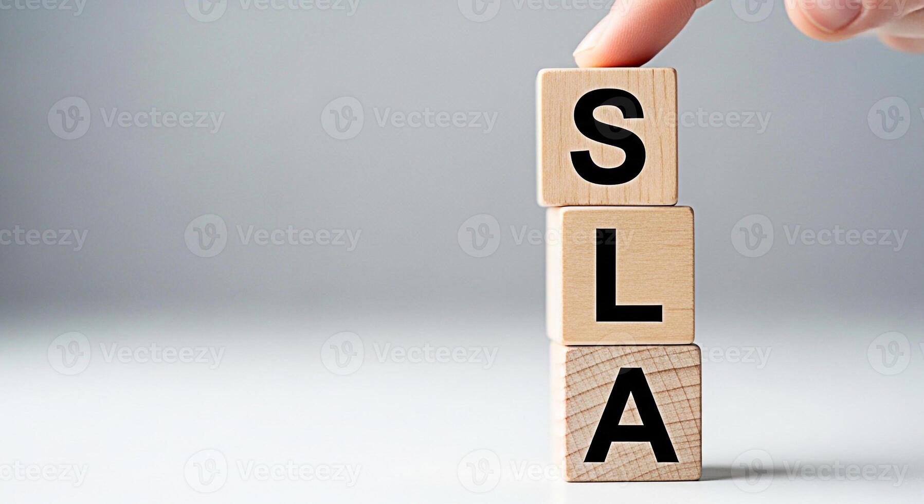 Hand placing a wooden block on top of a stack spelling SLA on a white surface representing Service Level Agreement symbolizing commitment and quality assurance in business operations photo