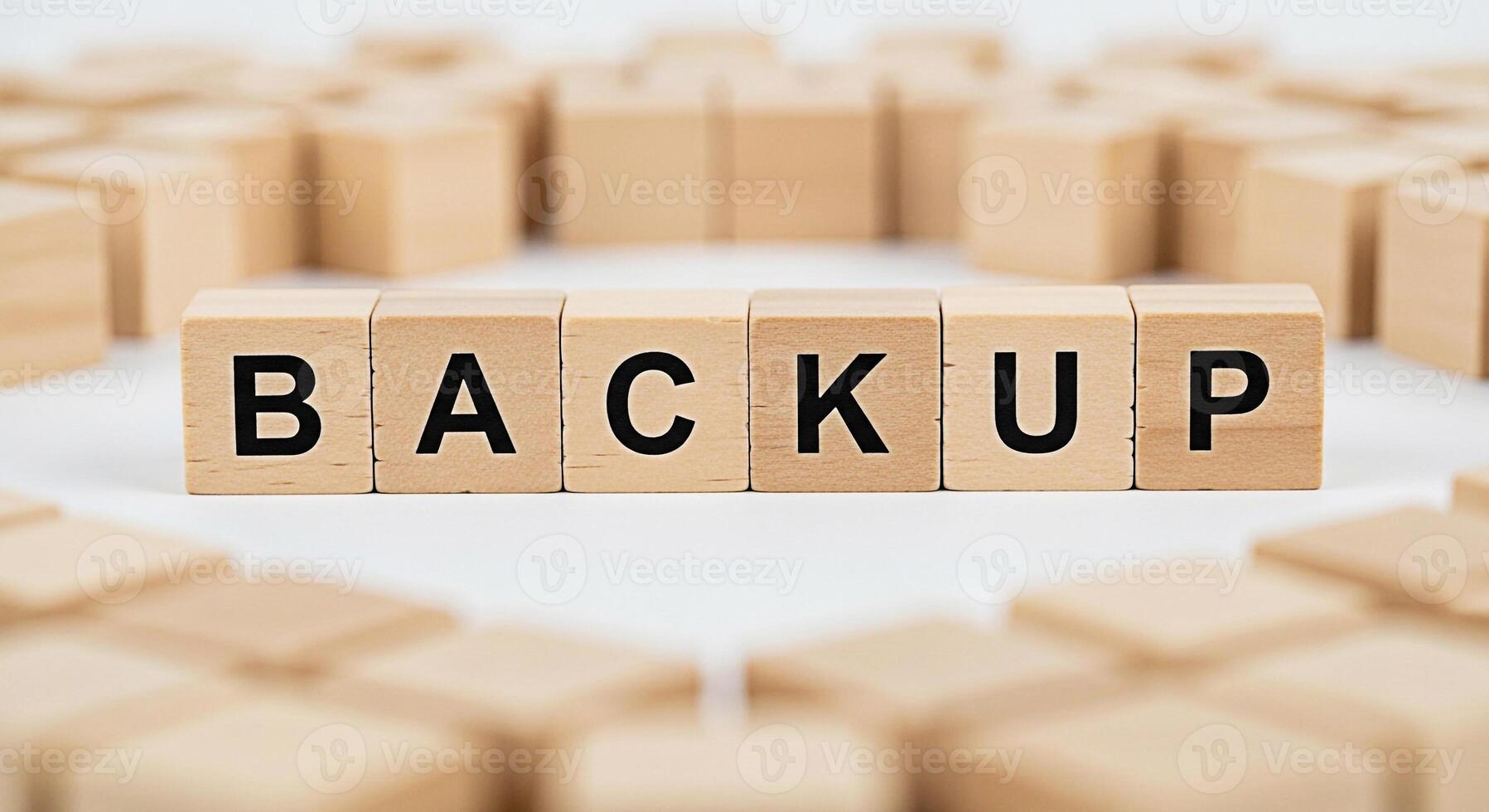 Wooden blocks spelling BACKUP on a white surface surrounded by other blocks representing data protection and security in a digital environment emphasizing the importance of safeguarding information photo