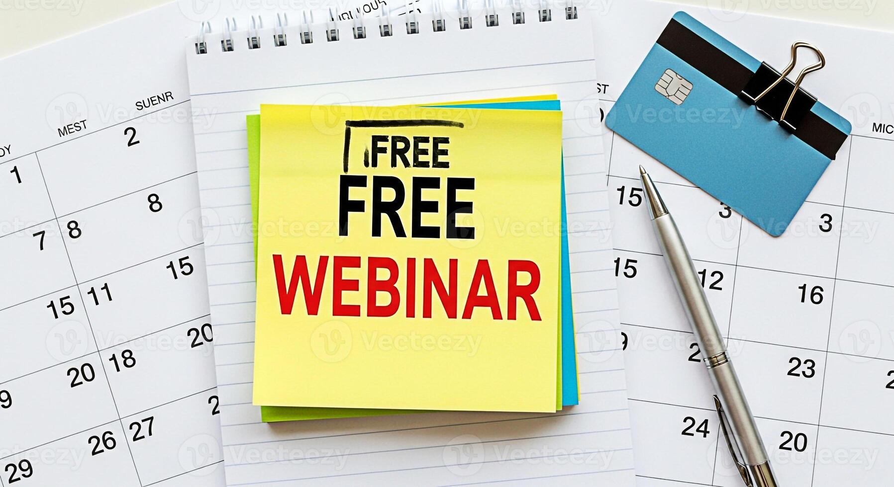Closeup of a calendar with a sticky note announcing a free webinar a credit card and a pen emphasizing the importance of planning and scheduling for online learning and financial awareness photo