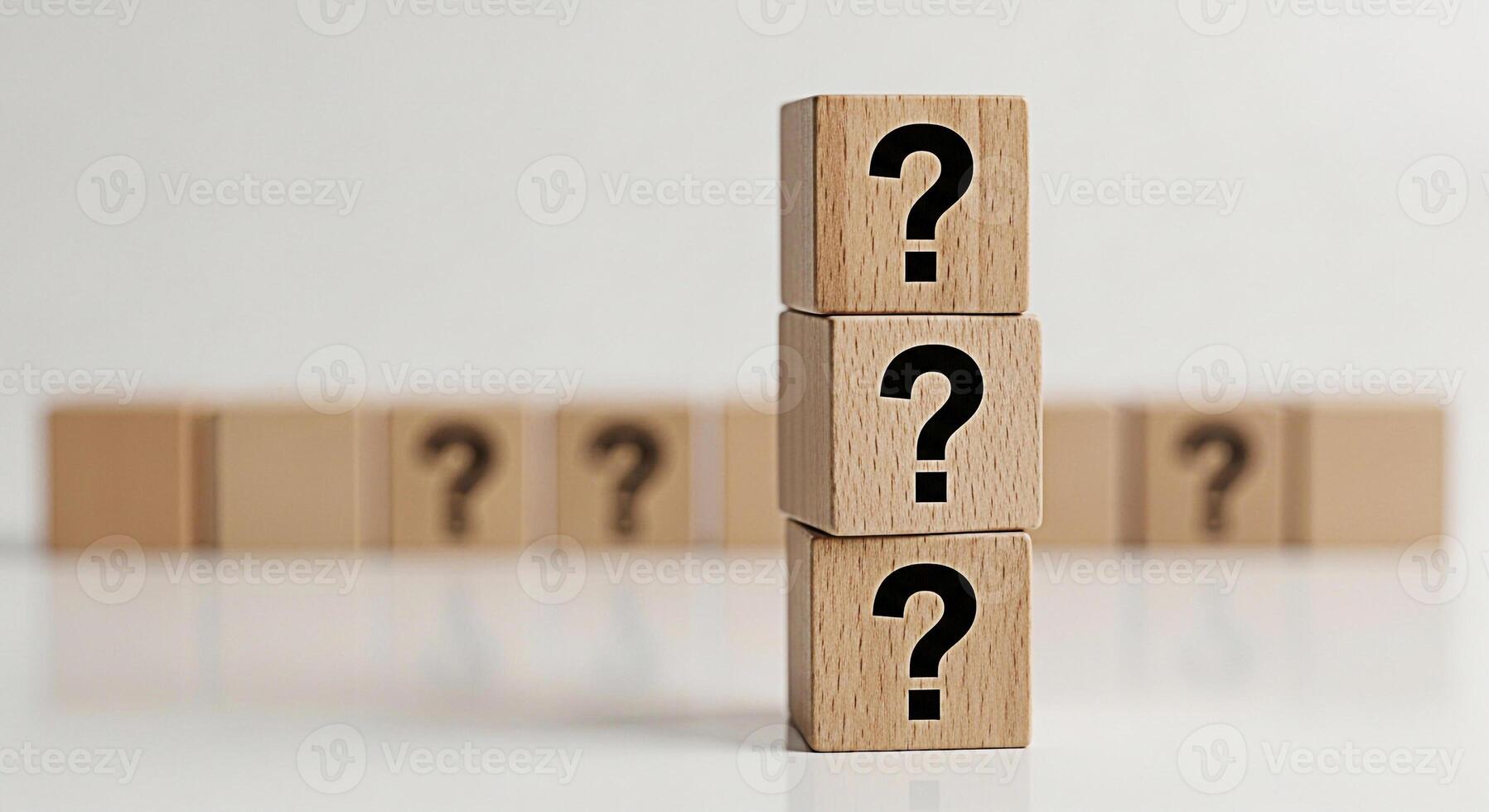 Stacked wooden blocks displaying question marks on a white surface representing uncertainty and inquiry in a minimalist setting evoking curiosity and the search for answers photo
