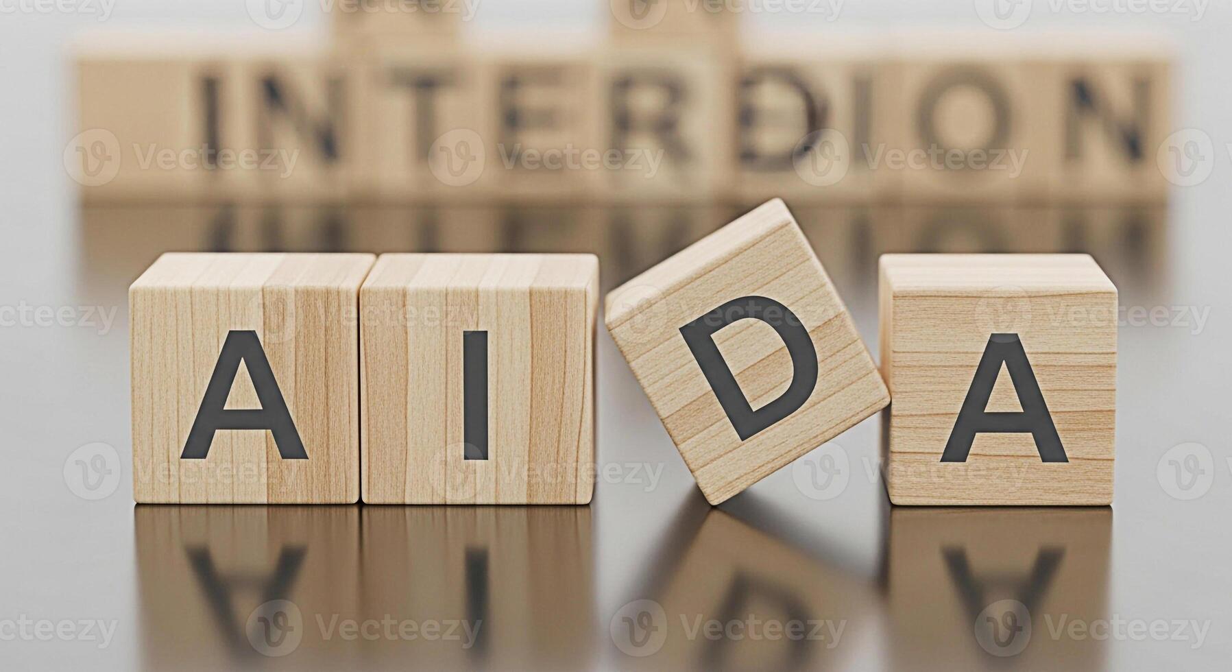 Wooden blocks spelling out AIDA representing the marketing funnel concept placed on a reflective surface symbolizing attention interest desire and action in a business strategy context photo