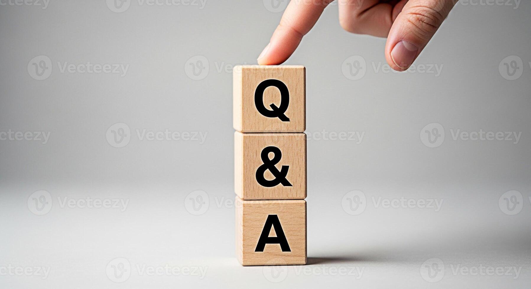 Finger touching wooden blocks stacked with QA letters in a bright studio representing questions and answers knowledge support and problemsolving fostering a sense of clarity and understanding photo