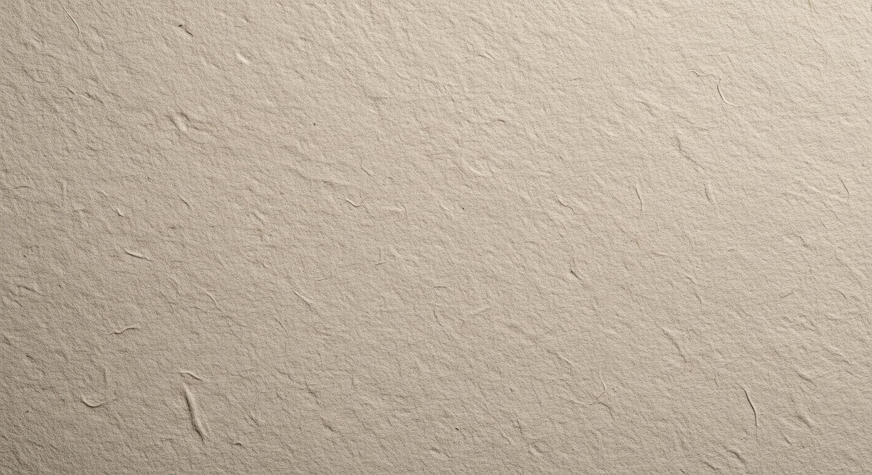 A close up shot of a beige textured surface with small fibers and uneven patches across the frame photo