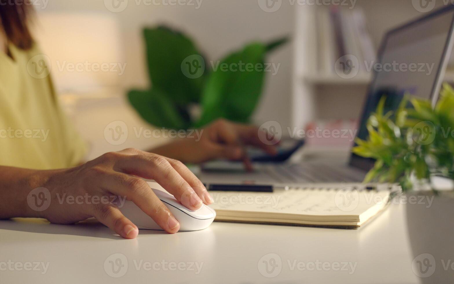 Close up woman hand click on wireless computer mouse working online on laptop computer at home. photo