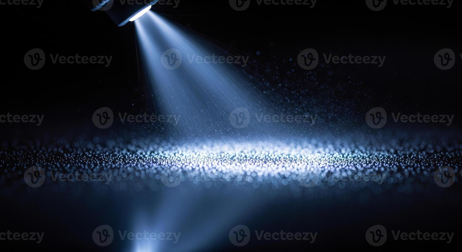 A beam of light illuminating a surface covered with small particles in a dark environment photo