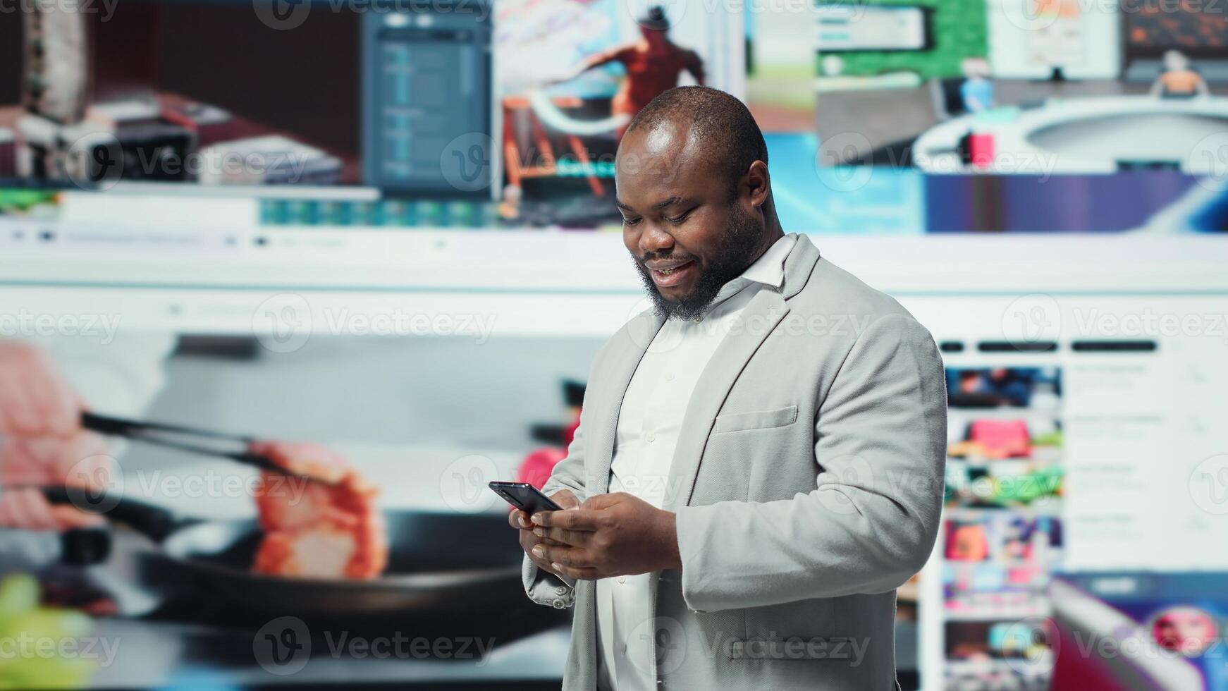 Happy person uses phone, doing engagement with multimedia content, sending likes. Joyous man browsing social networks feed on smartphone in front of dashboard featuring videos, camera A photo