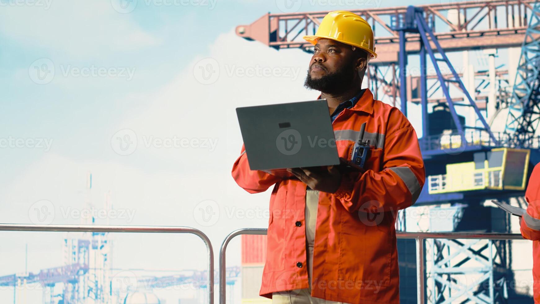Drilling rig inspector inspecting integrity of offshore platform infrastructure with laptop. Man working on drilling barge using diagnostic tools to detect malfunction in subsea pipelines photo
