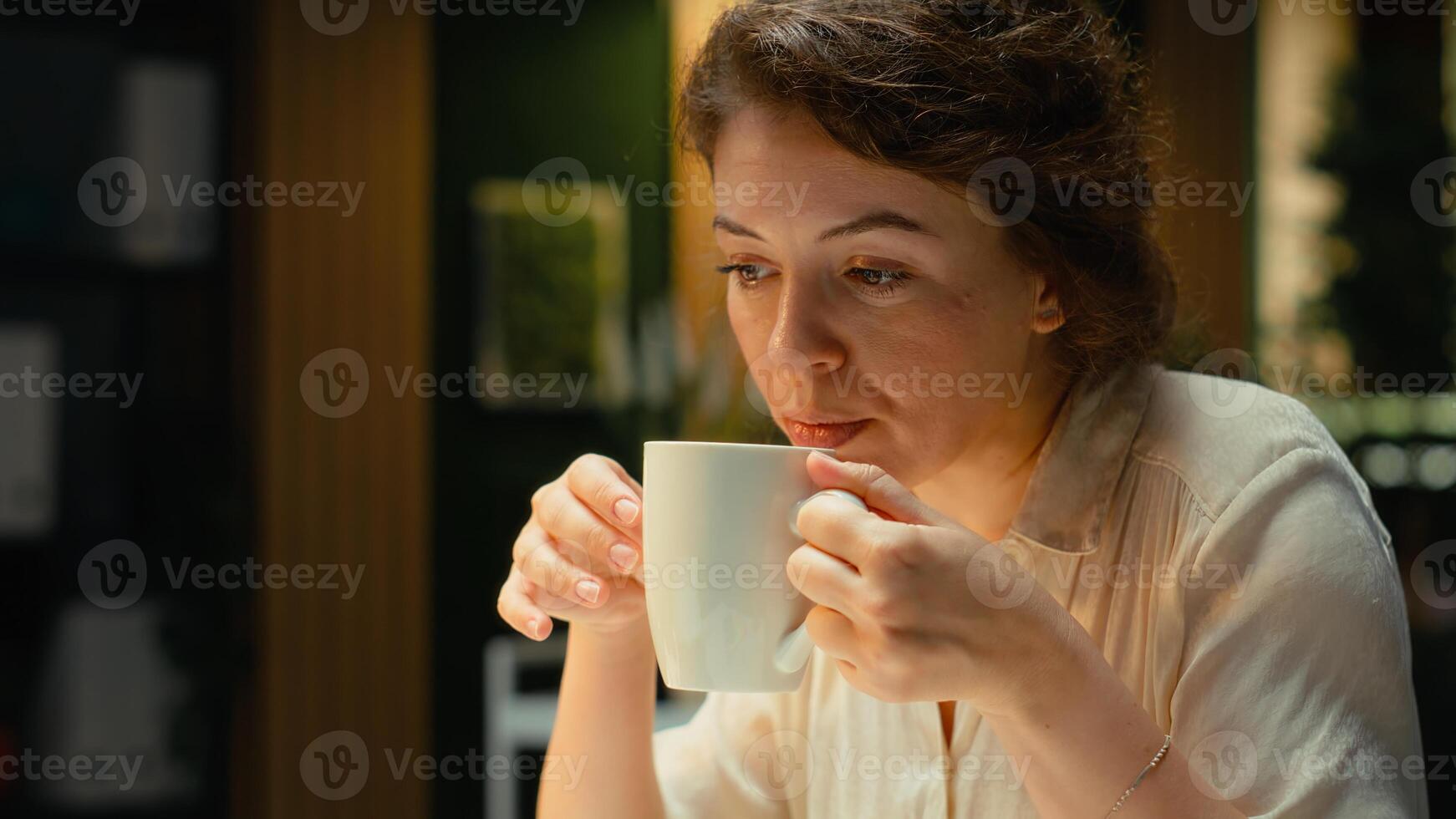 Company manager serving coffee at the office after hours while working late, researching documents and reports to create agenda for company development plan. After hours tasks. Camera B. photo