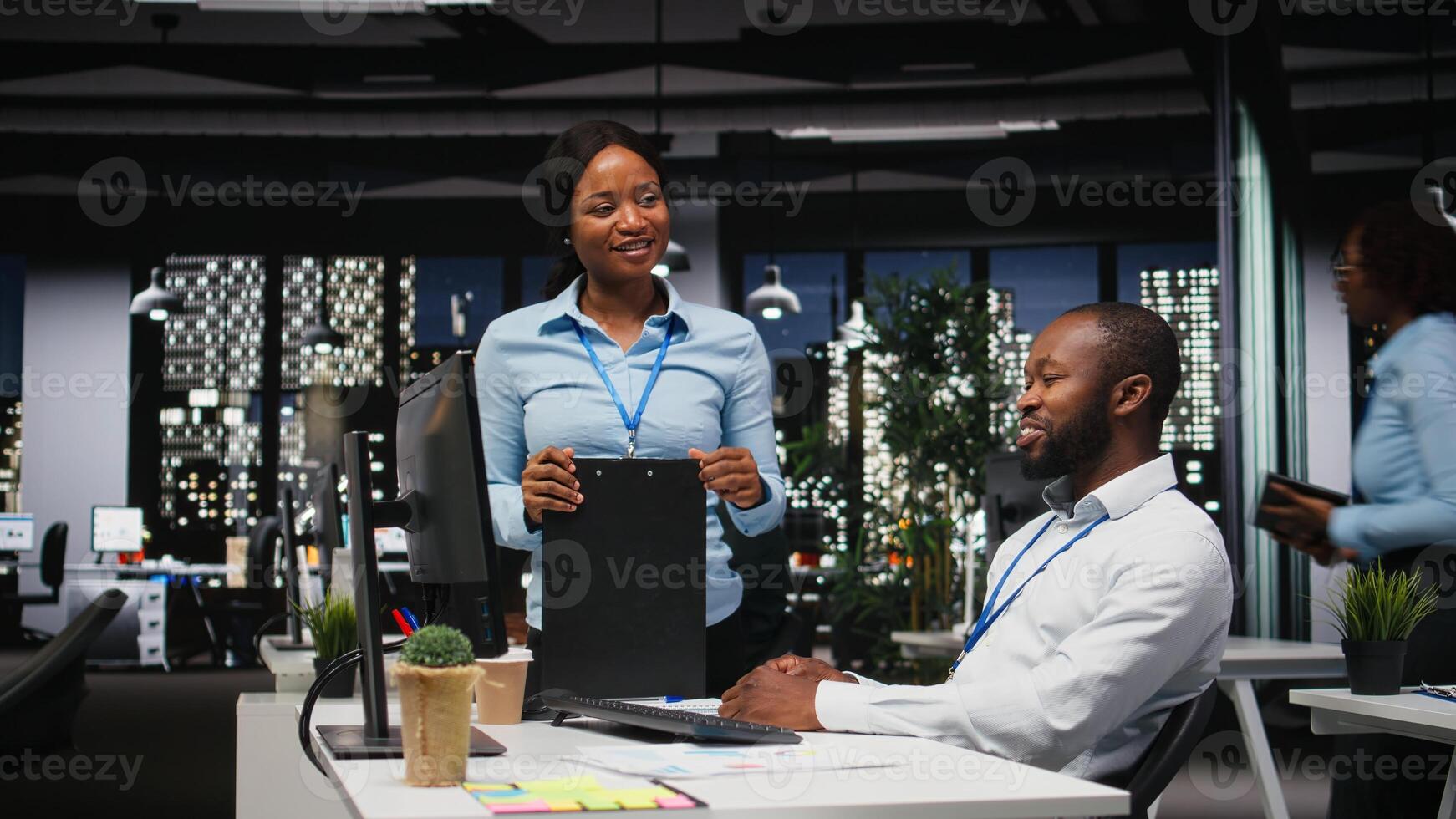 African american staff members engaged in project planning and report writing, using business data to ensure alignment with objectives. Building an agenda for future projects, after hours. photo