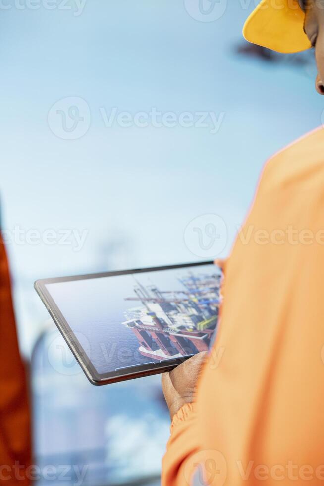 Close up of drilling rig expert using tablet app dashboard for anomaly detection during operation. Offshore platform employee use device application interface to control systems remotely photo
