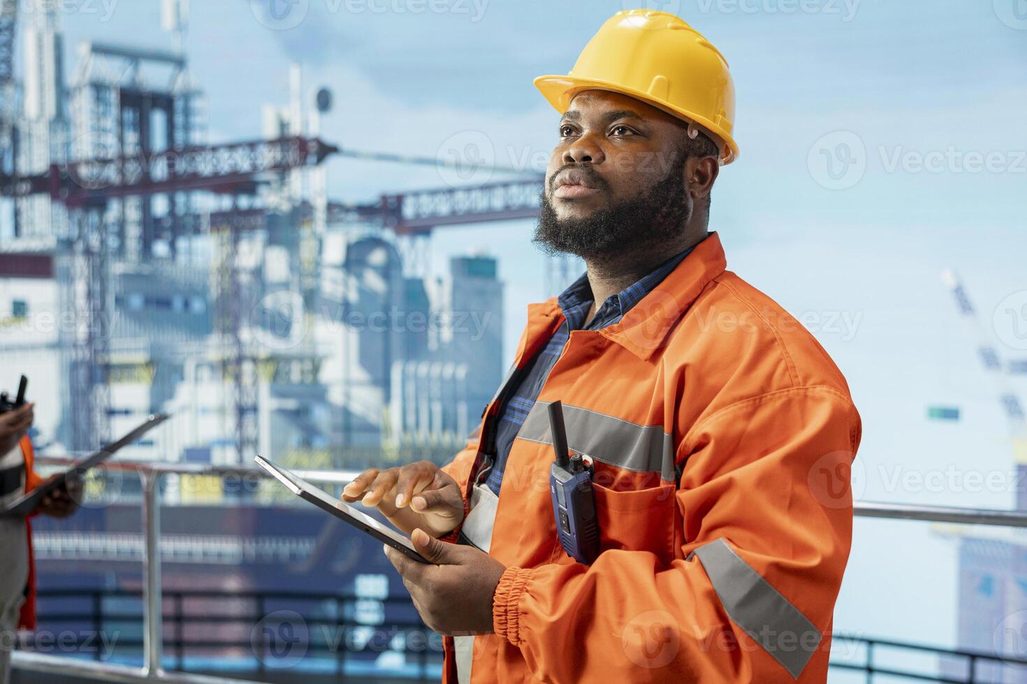 Offshore platform specialist uses performance management program on device to reduce downtime. Man use tablet application integrating sensor readings to manage industrial barge operations photo