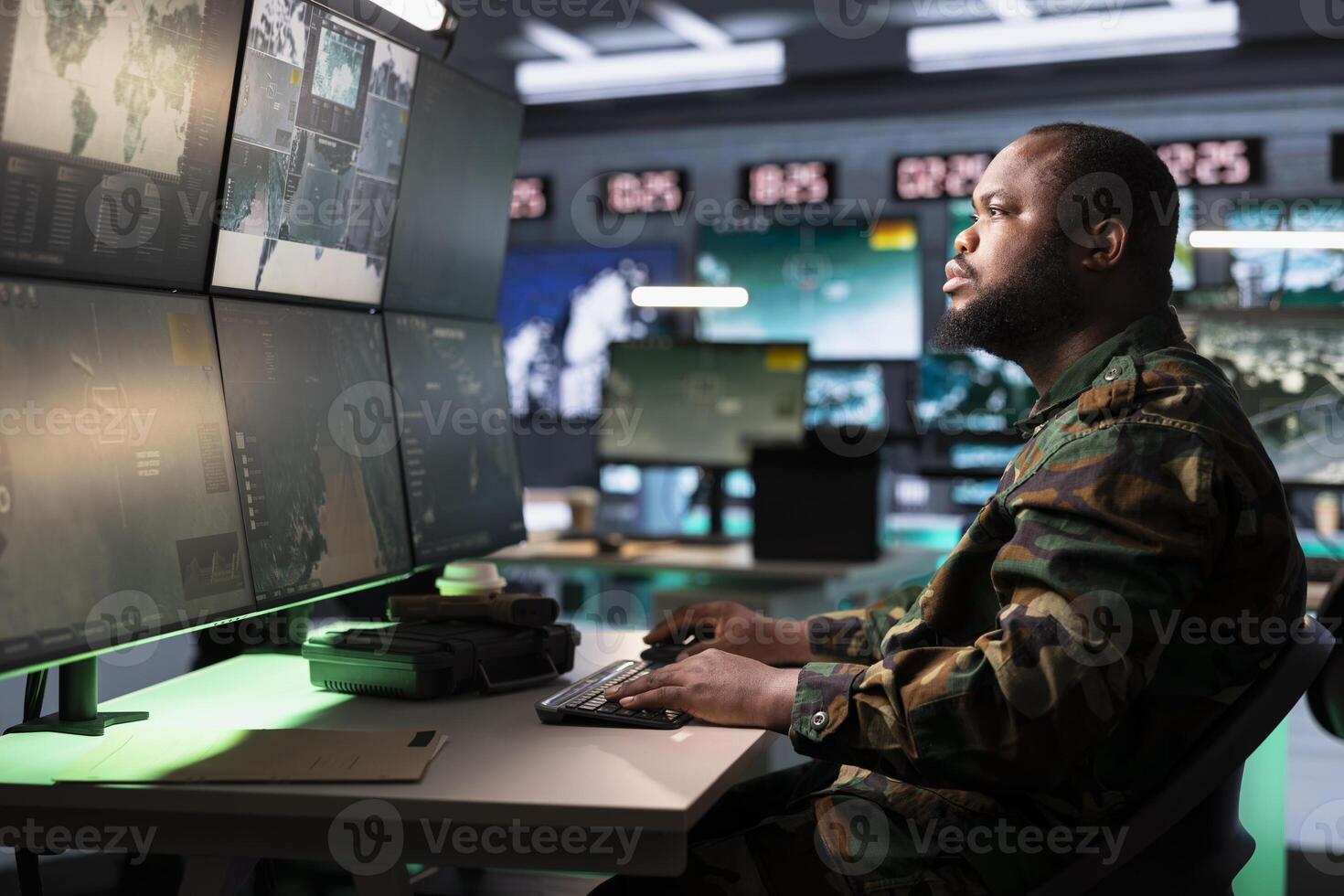 Army dispatcher working in command center housing operational missile defense system designed to intercept and destroy ballistic rockets. African american man tracking missiles using radar systems photo