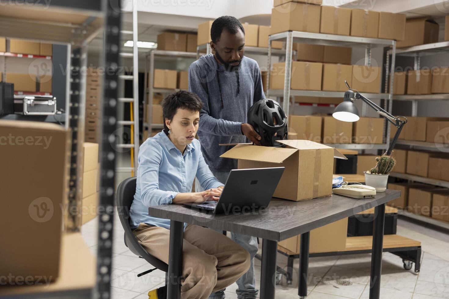 Small business diverse employees coordinating local shipment logistics and processing custom orders from a storage room filled with packages and inventory management. Distribution hub. photo