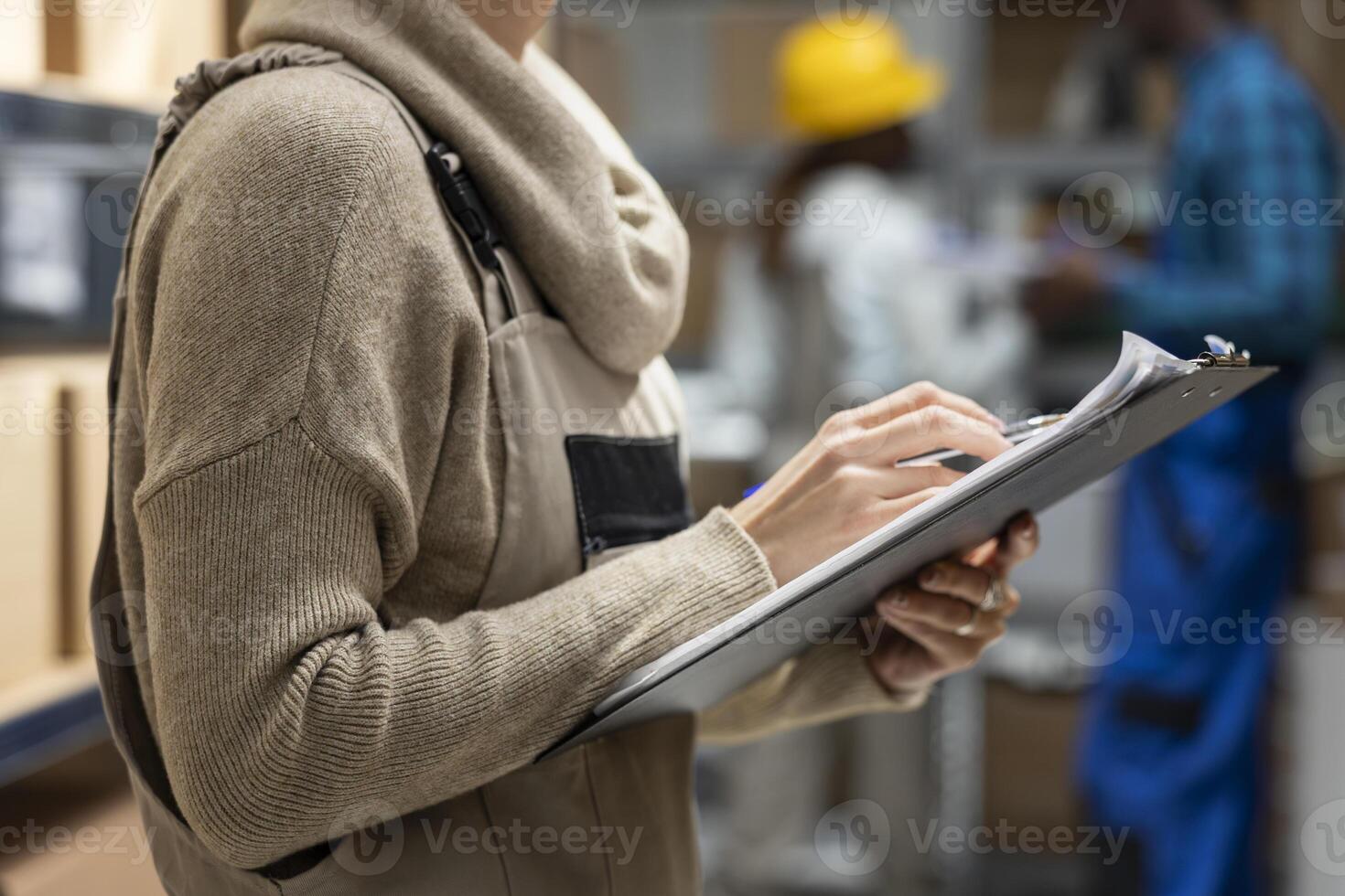 Logistics worker in a depot coordinating storage and package handling, solving distribution tasks before shipment process. Warehouse interior features crates and shelving for supply chain. photo
