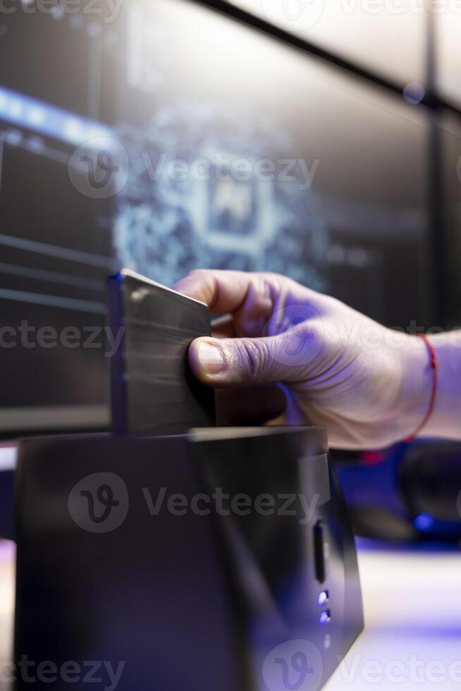 Close up of hacker using SSD to store data gathered from victims using spyware installed on their systems. Evil man inserting hard drive containing exploit used to gain unauthorized access photo