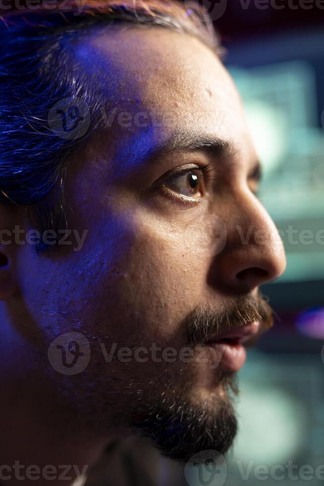 Close up of rogue technician looking at screen, using AI to evade security with stealth virus. Hacker in base of operation using deep learning tech to hide malicious exploit from cybersecurity photo