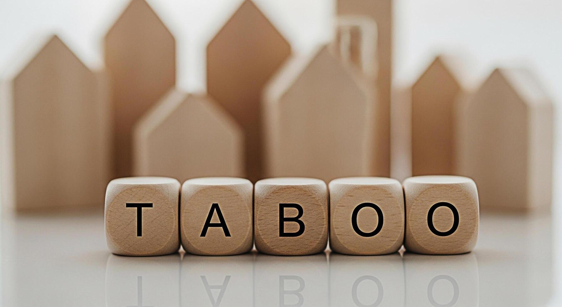 Wooden dice spelling TABOO in a minimalist setting with blurred house shapes in the background representing forbidden topics and creating a sense of mystery and intrigue perfect for social commentary photo