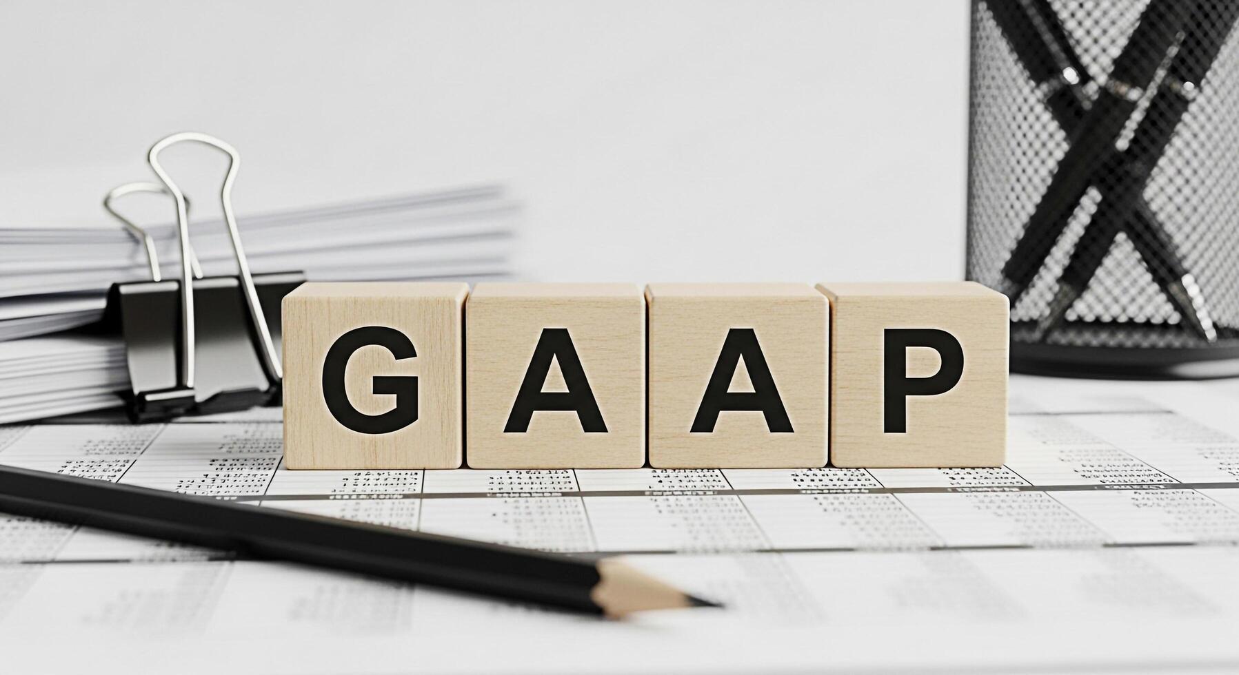 Wooden blocks spelling GAAP resting on financial documents in a bright office setting representing accounting principles and financial compliance conveying accuracy and transparency in business operat photo