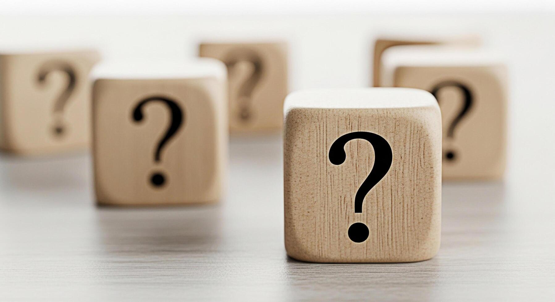 Wooden question mark blocks arranged on a neutral surface symbolizing uncertainty and the search for answers in a minimalist and thoughtprovoking composition perfect for illustrating complex problems photo