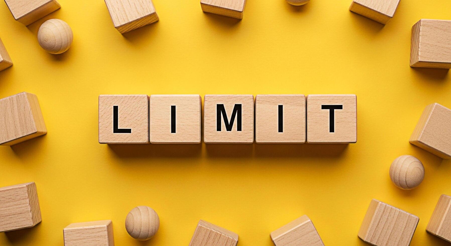 Wooden blocks spelling LIMIT on a vibrant yellow background surrounded by scattered wooden shapes symbolizing boundaries and constraints in a playful educational setting promoting awareness and unders photo