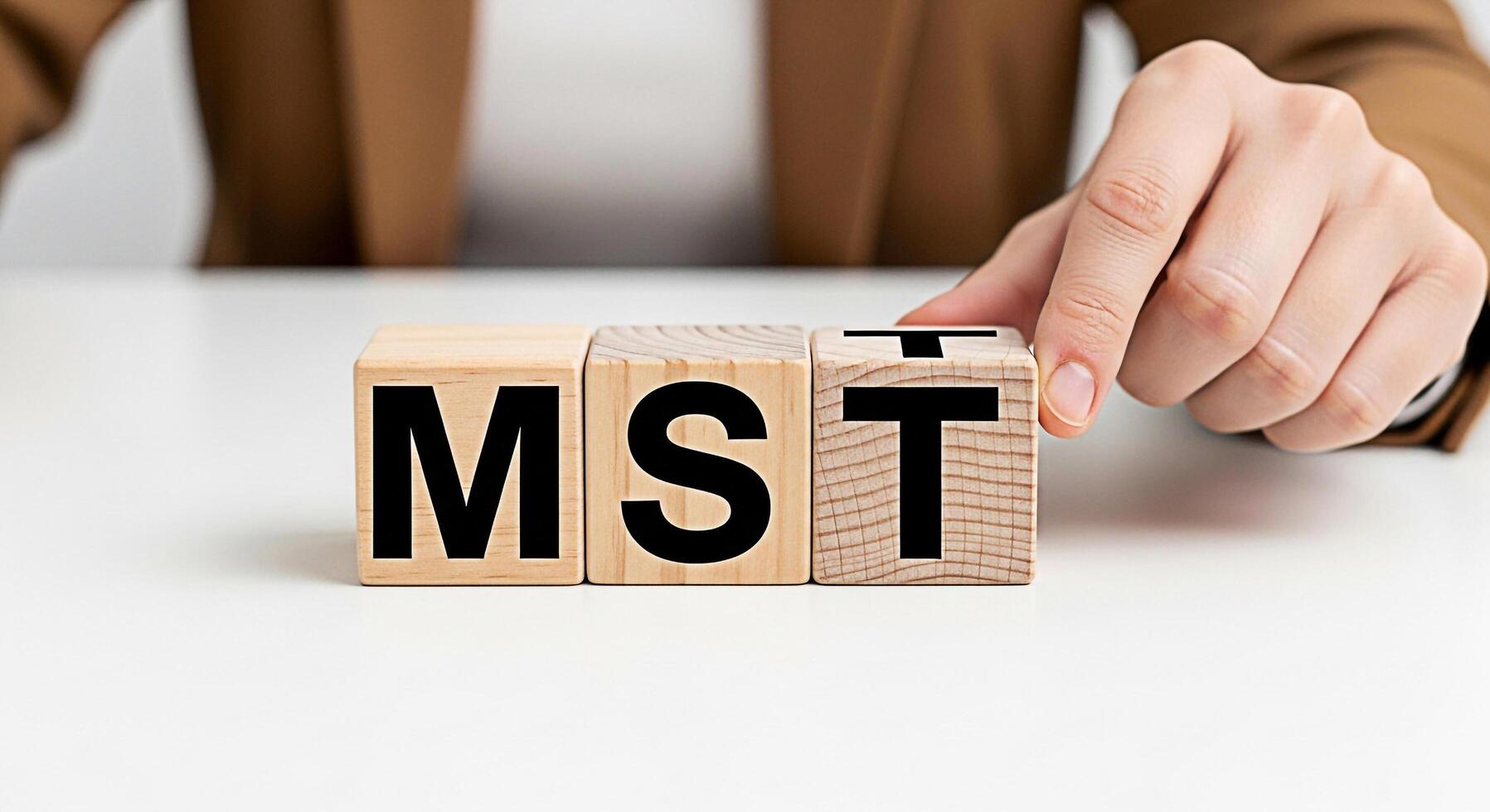 Hand arranging wooden blocks spelling MST on a white table symbolizing master of science and advanced education conveying a sense of knowledge achievement and academic success in a bright clean enviro photo