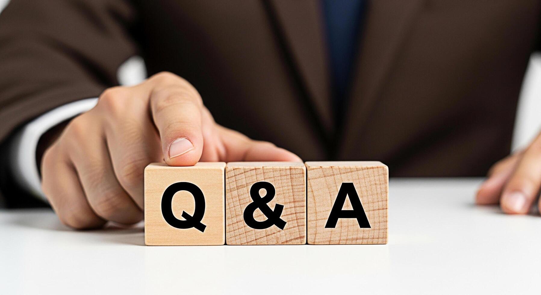 Business professional arranging wooden blocks with Q A on a clean white surface symbolizing questions and answers knowledge and solutions in a corporate and informative setting photo